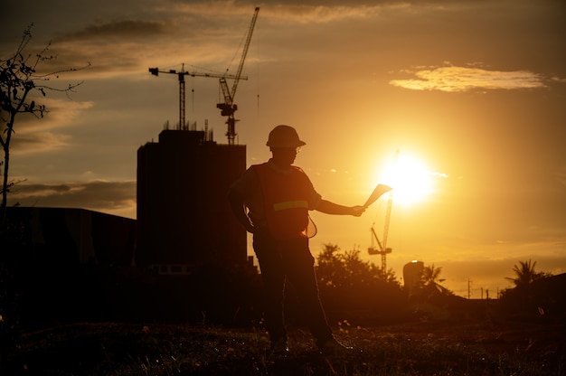 ingegnere maschio che lavora in cantiere all'ora di Silhouette Sunset