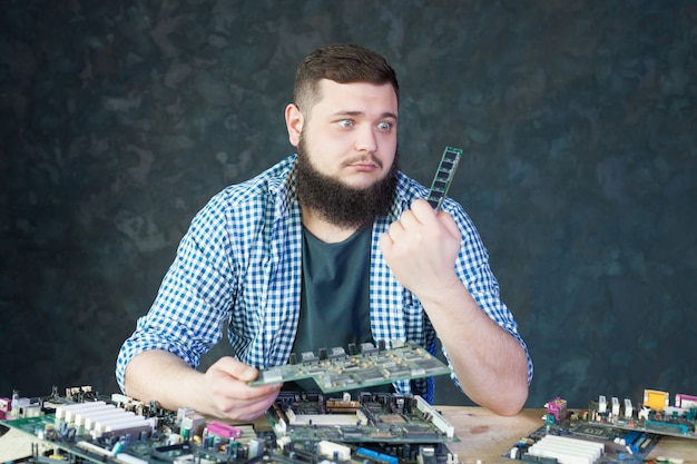 Ingegnere maschio lavora con componenti di computer rotti. Tecnologia di riparazione di dispositivi elettronici