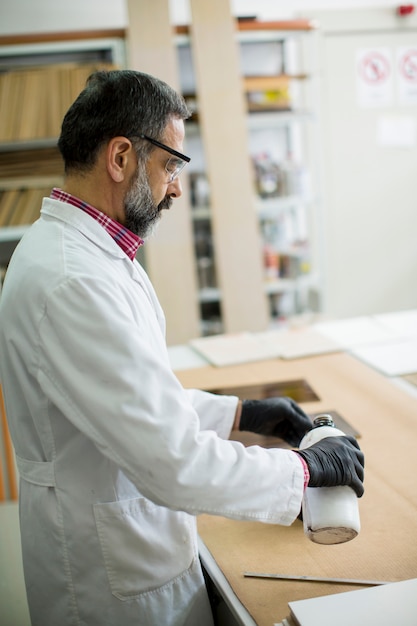 ingegnere maturo in laboratorio esamina piastrelle di ceramica