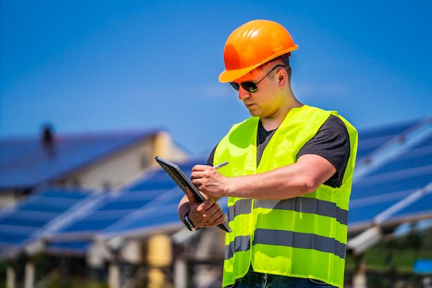 Ingegnere nel casco del lavoratore su sfondo di pannelli solari Pannello di energia solare Energia verde Elettricità Pannelli di energia elettrica