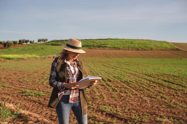 Ingegnere sul campo femminile che esamina la piantagione agricola Agronomo di integrazione donne nel campo