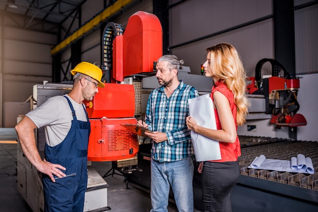 Ingegneri che controllano l'installazione della nuova macchina per plasma CNC