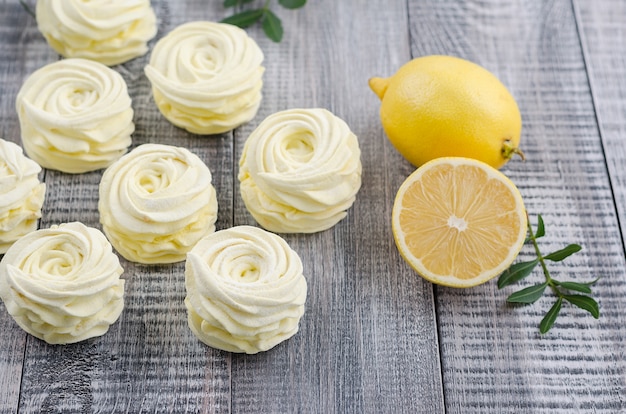 Ingiallisca, marshmallow della mela con il limone su fondo d&#39;annata di legno.