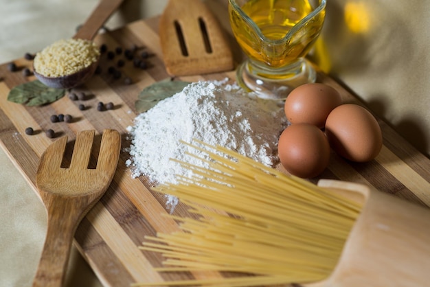 Ingredienti alimentari, pasta, farina, olio su tavola di legno