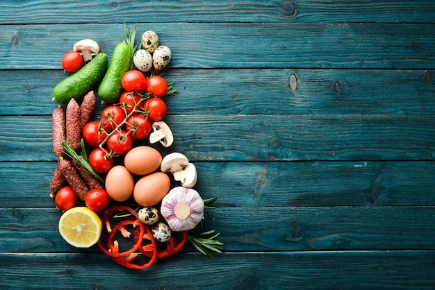 Ingredienti alimentari per cucinare Pomodori funghi uova di rosmarino e spezie su uno sfondo vecchio Vista dall'alto