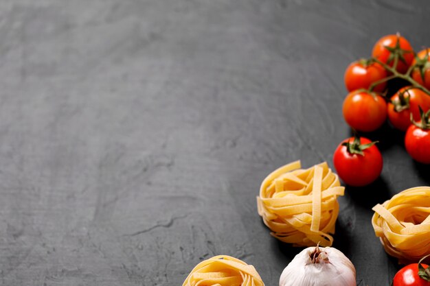 Ingredienti biologici freschi di ricette italiane. Pasta, pomodori, aglio. Concetto di cibo sano.