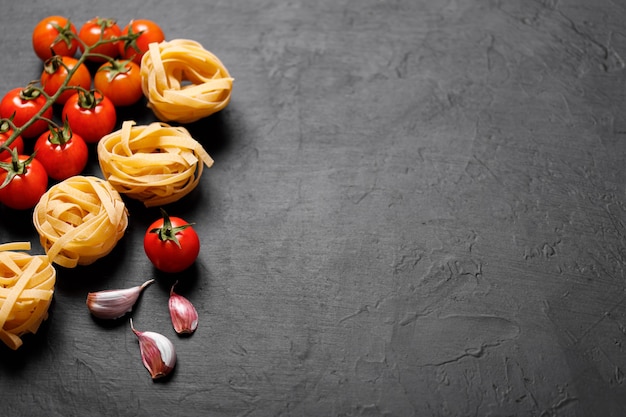 Ingredienti biologici freschi di ricette italiane. Pasta, pomodori, aglio. Concetto di cibo sano.