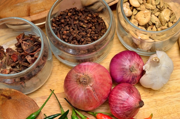 Ingredienti da cucina. Spezie ed erbe aromatiche con cipolla e aglio su tavola di legno