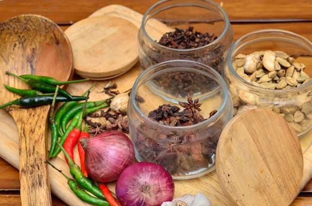 Ingredienti da cucina. Spezie ed erbe aromatiche con cipolla e aglio su tavola di legno