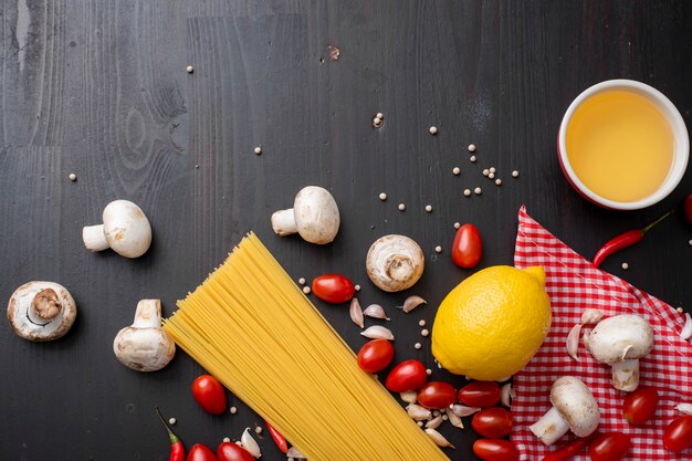 Ingredienti degli spaghetti sullo scrittorio di legno nero, vista superiore.