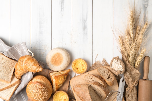 ingredienti del forno e del pane su fondo di legno bianco, vista superiore e spazio della copia