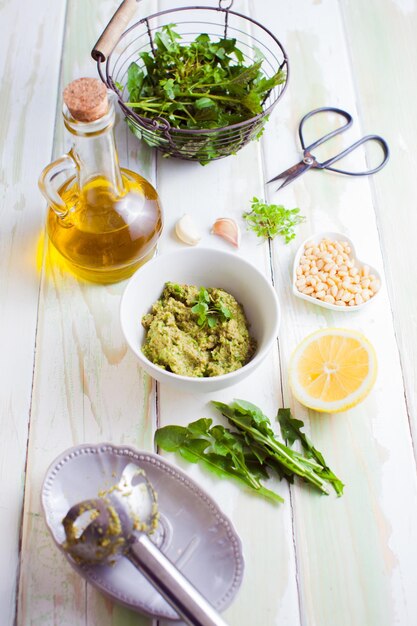 Ingredienti del pesto di erbe selvatiche fresche su fondo di legno