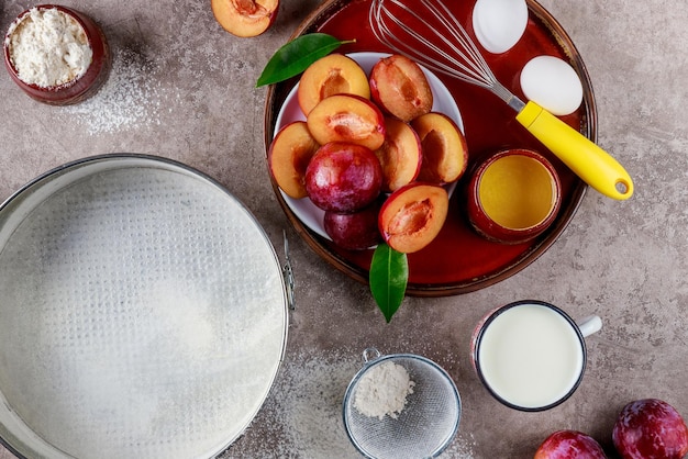 Ingredienti del processo di cottura uova, frusta, teglia sul piano della cucina.