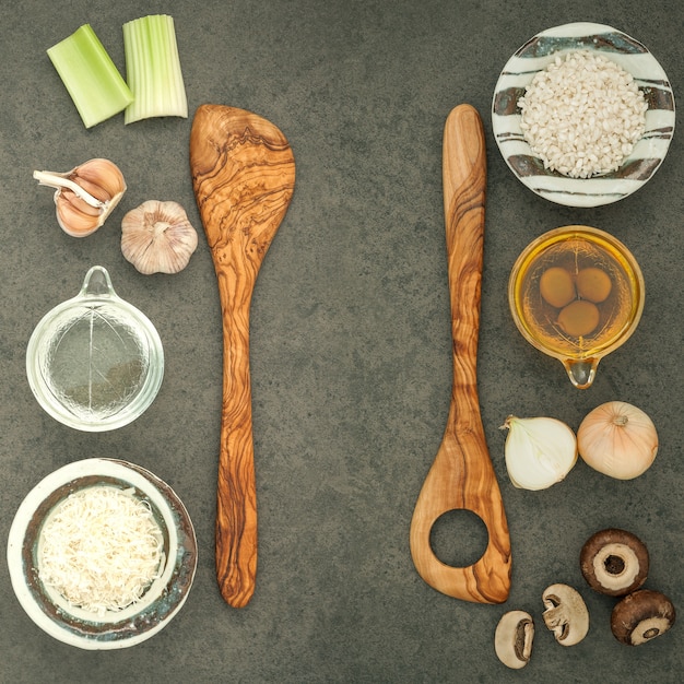 Ingredienti del risotto dei funghi su fondo di pietra rustico scuro con lo strato piano e lo spazio della copia.