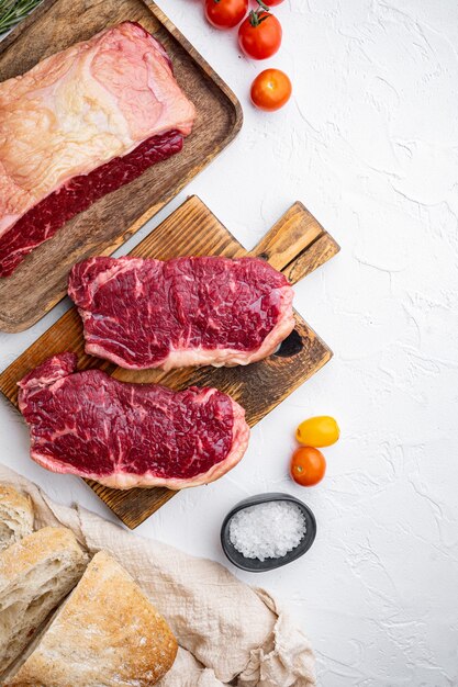 Ingredienti dell'hamburger di bistecca con carne di manzo, carne marmorizzata, sul tavolo bianco, vista dall'alto,