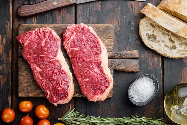 Ingredienti dell'hamburger di bistecca con carne di manzo, carne marmorizzata, sul tavolo di legno scuro, vista dall'alto