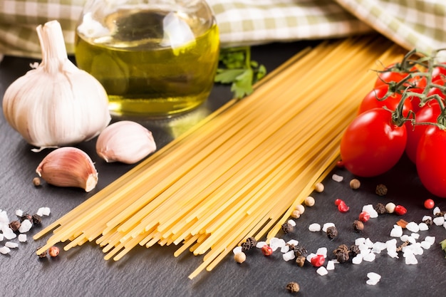 Ingredienti della pasta e spezie sulla superficie dell'ardesia nera. Vista dall'alto.