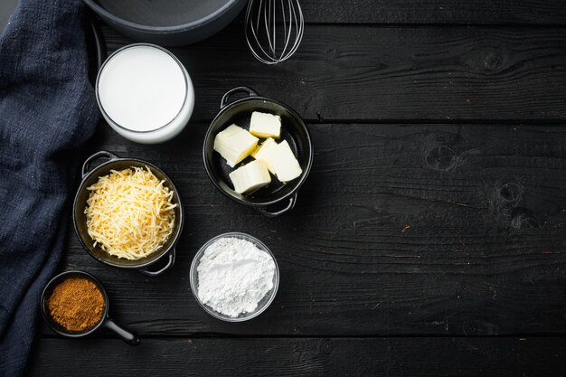 Ingredienti della salsa besciamella sulla vista superiore del tavolo in legno nero