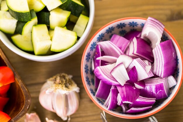 Ingredienti freschi per la preparazione di verdure miste arrosto sul tavolo.