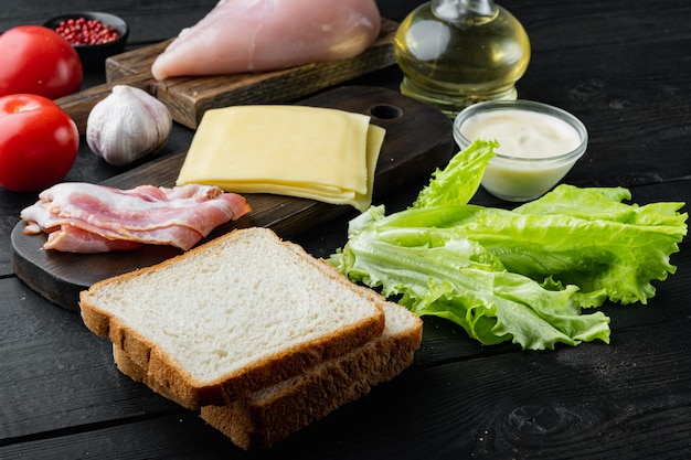 Ingredienti freschi per un gustoso panino, su fondo di legno nero