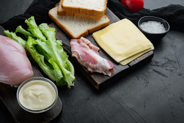 Ingredienti freschi per un gustoso panino, su sfondo nero con copia spazio per il testo