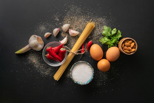 Ingredienti grezzi per la cottura degli spaghetti alla marinara con uova in camicia distese piatte e copia gli spazi