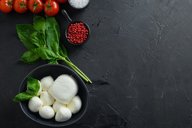 Ingredienti insalata caprese: palline di mozzarella con pomodoro e basilico