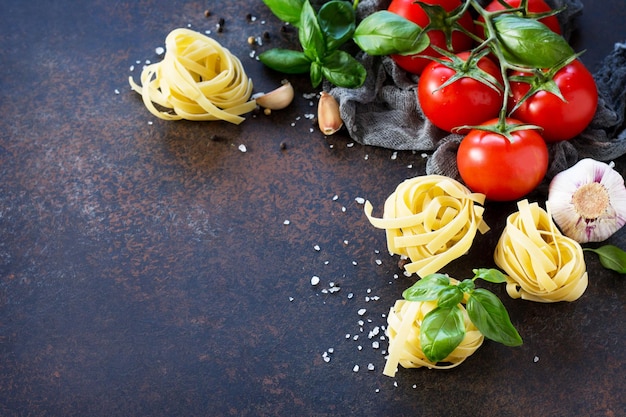 Ingredienti per cucinare la pasta aglio pomodori basilico e spezie Sfondo di cibo