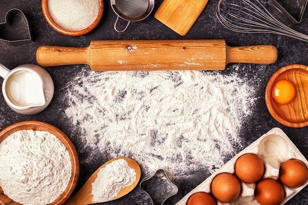 Ingredienti per cuocere farina, cucchiaio di legno, mattarello, uova