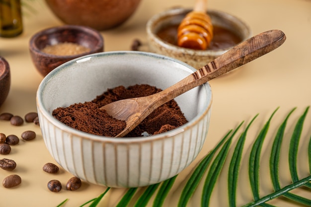 Ingredienti per fare in casa lo scrub per la cura della pelle al caffè su un tavolo vicino a cosmetici eco-compatibili