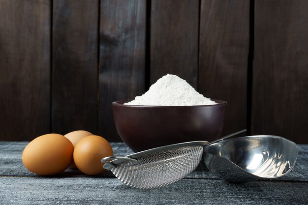 Ingredienti per fare la pasta. farina e uova sul tavolo della cucina con copia spazio.