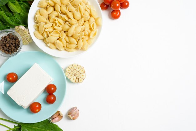 Ingredienti per formaggio feta al forno con pomodori e pasta, vista dall'alto di aglio pepe.