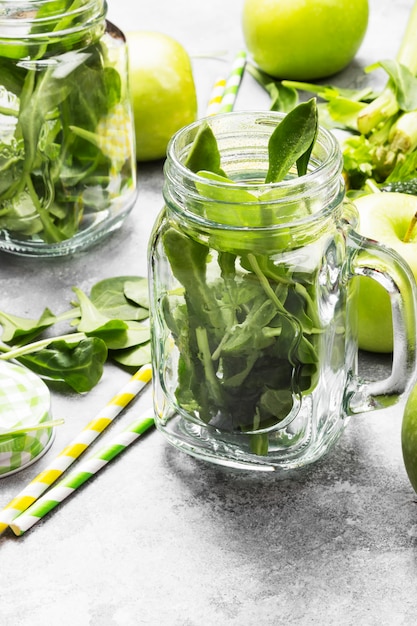 Ingredienti per frullato verde - mele, spinaci, sedano, avocado su uno sfondo chiaro