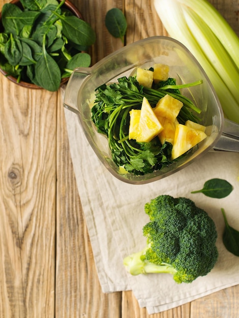 Ingredienti per frullato verde prezzemolo spinaci broccoli e sedano su tavola di legno