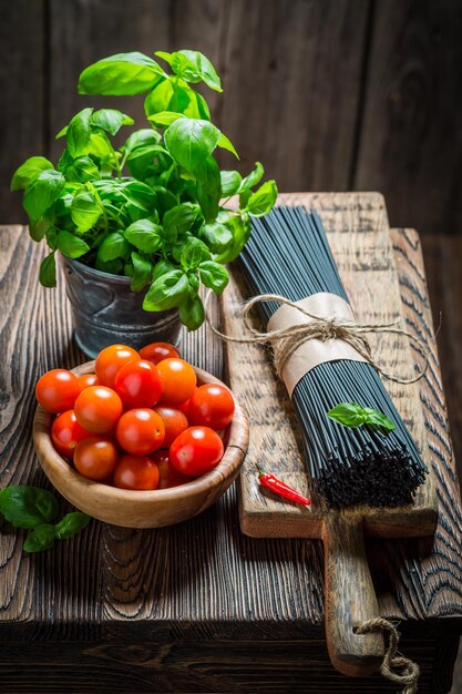 Ingredienti per gli spaghetti neri al basilico e pomodori