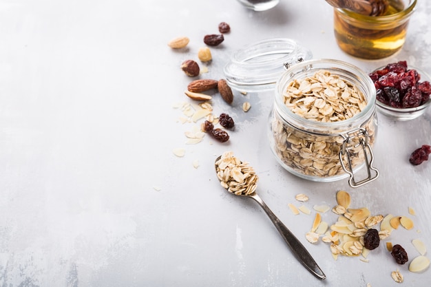 Ingredienti per granola di farina d&#39;avena casalinga in vaso di vetro.