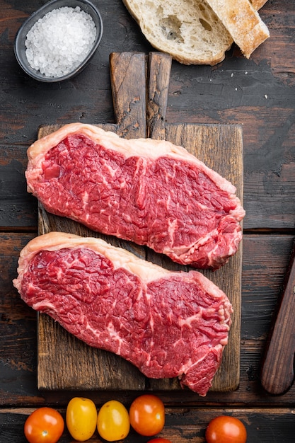 Ingredienti per hamburger di bistecca di manzo crudo, con carne marmorizzata, sul vecchio tavolo in legno, vista dall'alto,