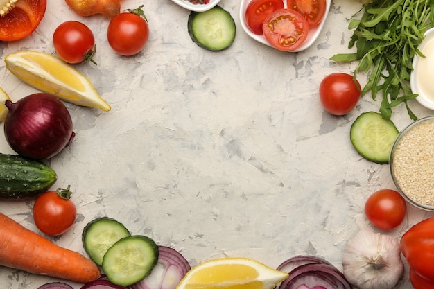 Ingredienti per la cottura dell'insalata. frame da Varie verdure e spezie carota, pomodoro, cipolla, cetriolo, pepe e rucola su sfondo chiaro. vista dall'alto.