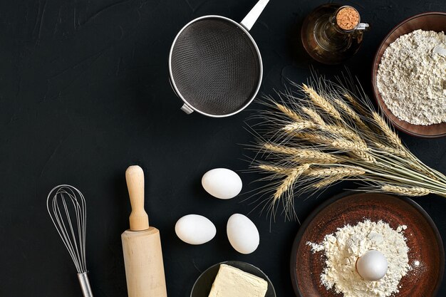 Ingredienti per la cottura della pasta sul tavolo da cucina nero Vista dall'alto con spazio per il testo