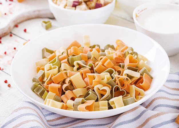 Ingredienti per la cottura di pasta cremosa con pollo e melanzane servita nel piatto fondo.