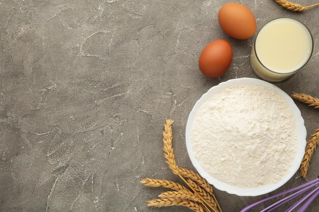 Ingredienti per la cottura o la cottura di uova farina mattarello burro latte su sfondo grigio Torta di biscotti o ricetta torta