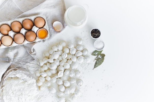 Ingredienti per la modellazione di gnocchi fatti in casa. Uova, latte, farina, sale, pepe, carne.