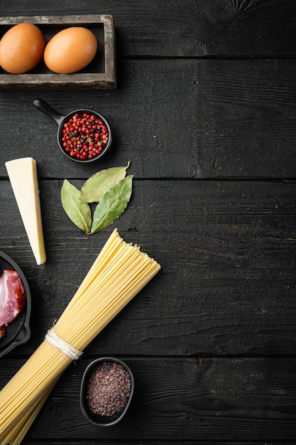 Ingredienti per Pasta Carbonara. Set di piatti italiani tradizionali, sul tavolo di legno nero, vista dall'alto laici piatta, con spazio di copia