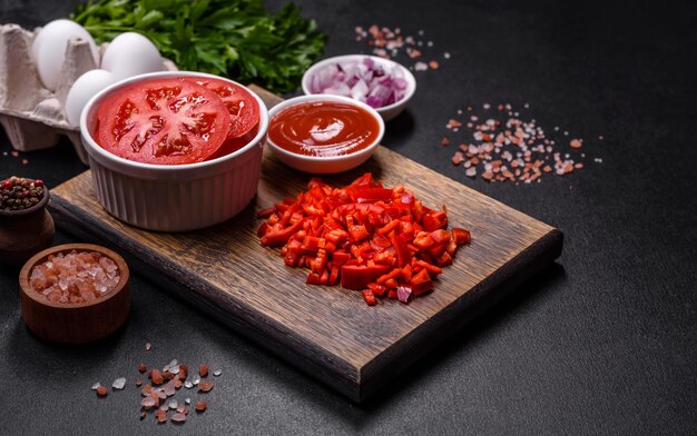 Ingredienti per preparare piatti shakshuka con uova fritte con salsa di pomodoro, spezie ed erbe aromatiche