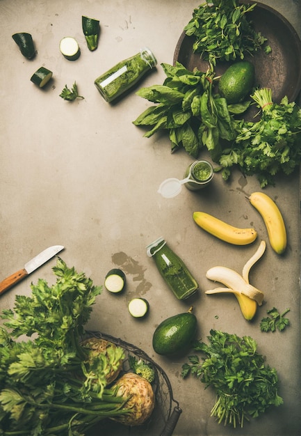 Ingredienti per preparare un frullato verde su sfondo di cemento