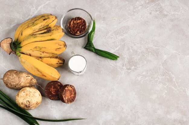 Ingredienti Preparazione per la composta di banana e patate dolci (Kolak Pisang Ubi). Banana matura, patata dolce, zucchero di palma (Gula Merah), foglie di pandan e latte di cocco. Popolare per la colazione del Ramadan