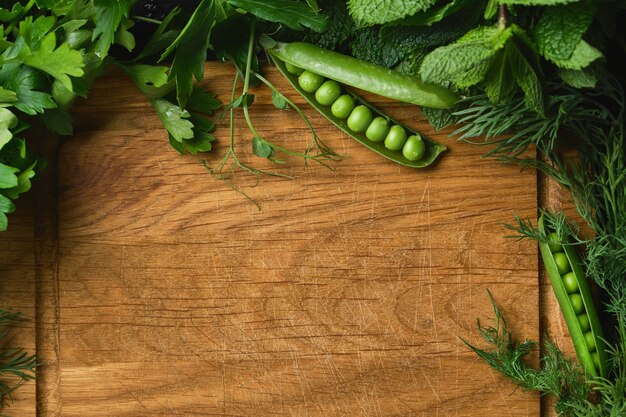 Ingredienti vegetali crudi freschi per una cucina sana con tagliere in legno rustico