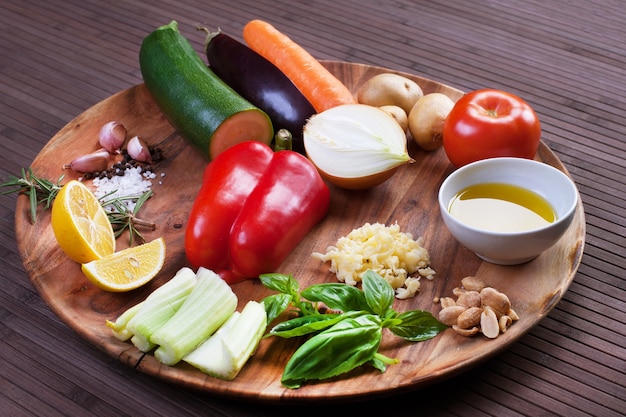 Ingredienti verdure per zuppa con pesto e basilico su un piatto di legno. Immagine di riserva.