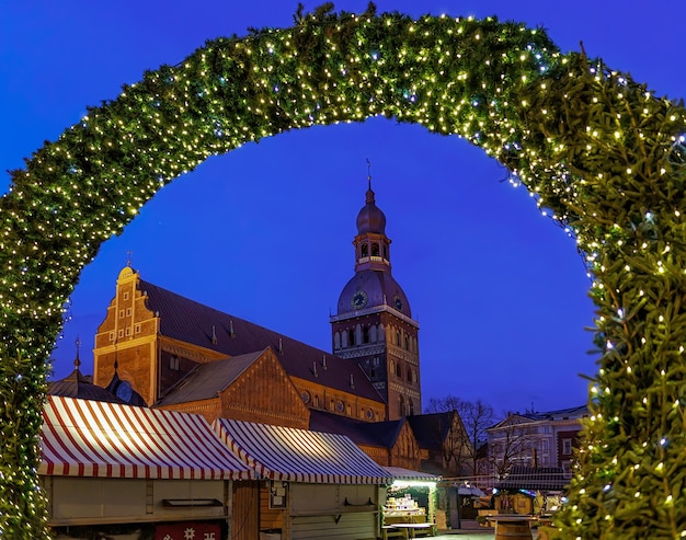 Ingresso al mercatino di Natale e alla Cattedrale di Riga di notte nella vecchia Riga, Lettonia. Il mercato si svolge ogni anno a dicembre. La cattedrale fu costruita nel 1211 dal vescovo livoniano Alberto di Riga.