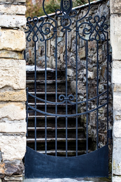 Ingresso con muro di pietra in un giardino, porta d'ingresso chiusa di sicurezza.